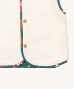 A close up of the Little Green Radicals reversible gilet in red foxes and sherpa lined. Showing the white sherpa fleece detail 