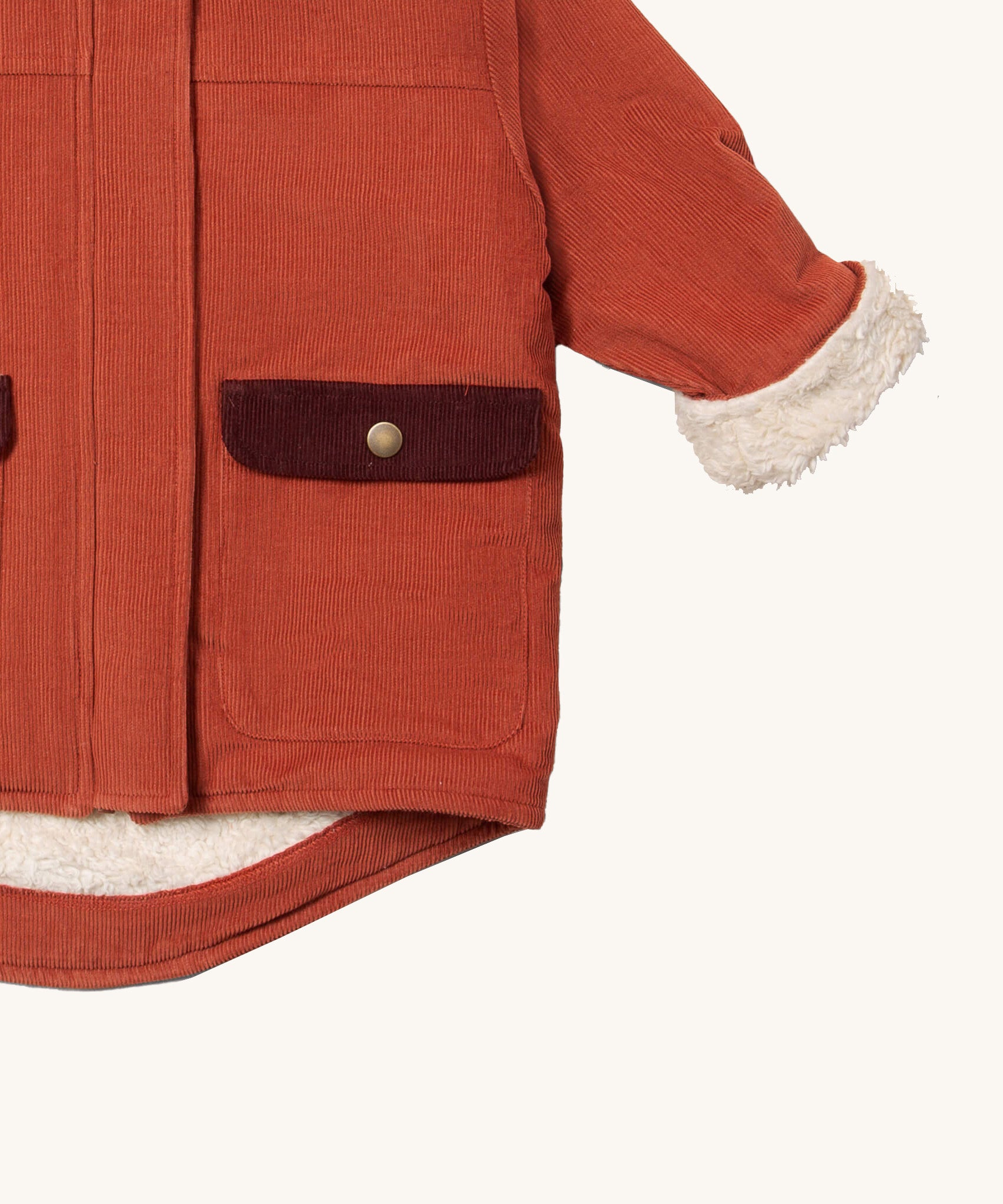 A close up of the Little Green Radicals ginger sherpa toasty coat available at  Babipur. Showing the sherpa fleece cuff for extra warmth and pocket detail with popper fasteners. 