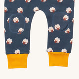 A close up of the Little Green Radicals comfy joggers in sleeping sheep showing kneepatch detail and yellow cuff trim on navy organic cotton fabric