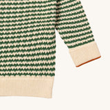 A close up of the Little Green Radicals snuggly knitted jumper in olive stripe available at Babipur. Showing the green and cream stripe knit detail and the matching cream turned up cuff for size adjusting