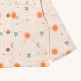A close up of the Little Green Radicals classic pyjama top from the moon and sun classic set. showing the pocket and button fastener detail on light pink organic cotton fabric.