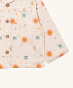 A close up of the Little Green Radicals classic pyjama top from the moon and sun classic set. showing the pocket and button fastener detail on light pink organic cotton fabric.