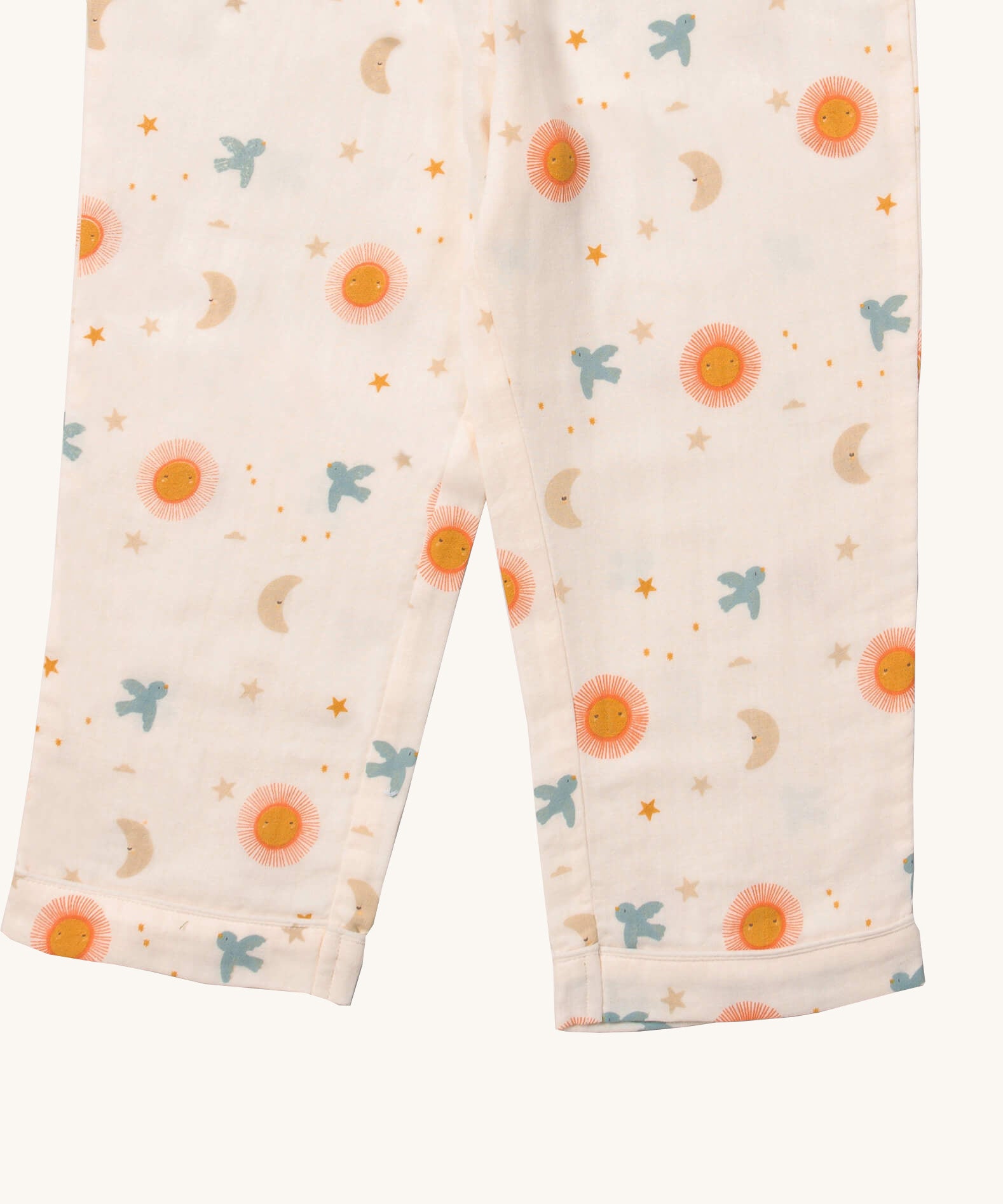 A close up of the Little Green Radicals classic pyjama bottoms from the sun and moon classic set. Showing the leg cuff detail and a close up of the starry night and flying blue birds print on light pink organic cotton fabric.