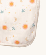 A close up of the sun and moon Little Green Radicals hooded blanket. Showing the cute sun and moon print detail and white trim detail on white organic cotton fabric