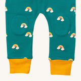 A close up  the Little Green Radicals turquoise rainbow joggers showing the stitched on knee patches  and yellow cuff trim on organic cotton fabric