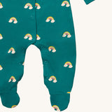 A close up of the Little Green Radicals turquoise rainbow baby grow, showing the popper fastener detail around the crotch on turquoise organic cotton fabric with cute rainbow prints.