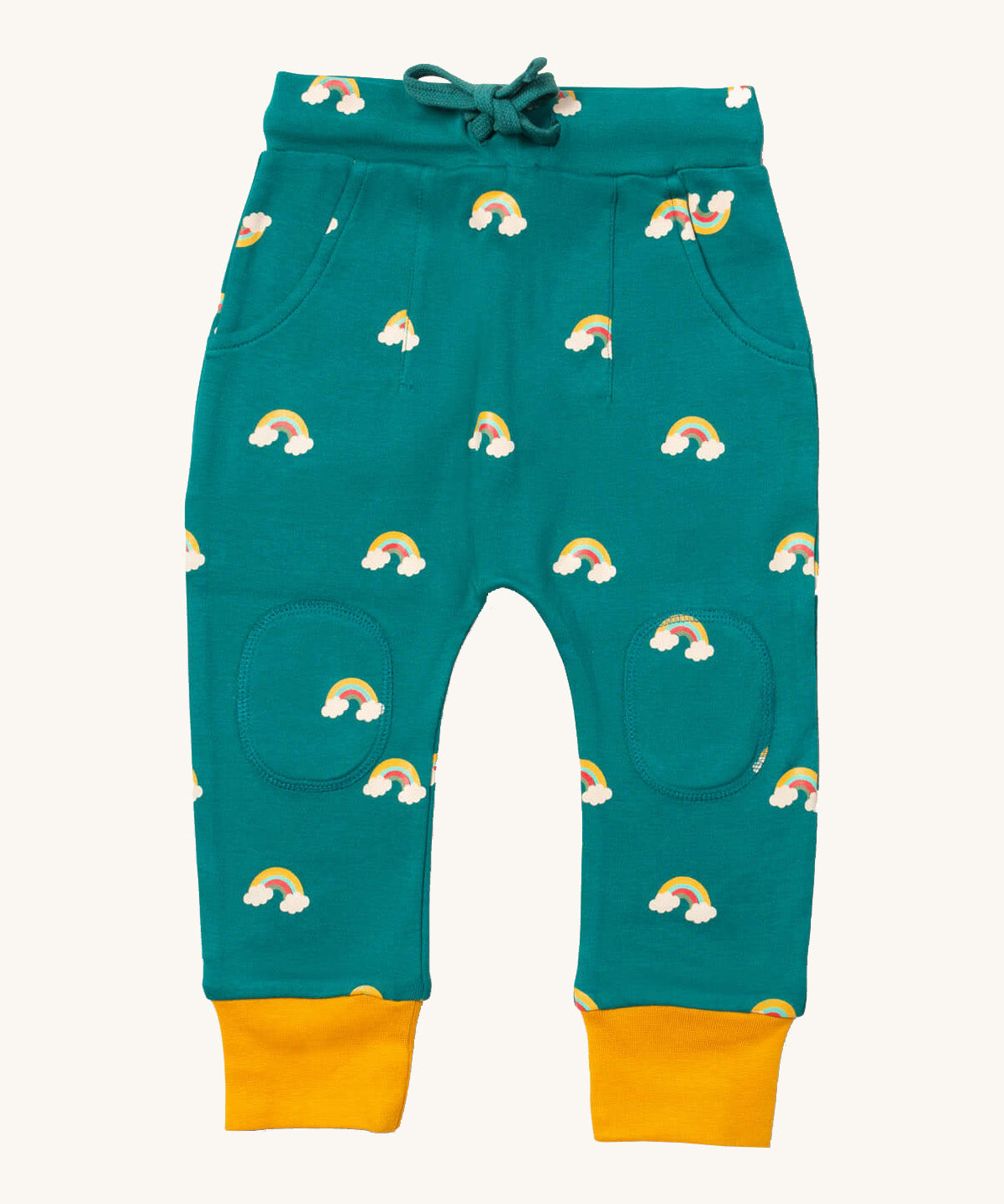 Little Green Radicals comfy joggers in turquoise rainbow available at Babipur.. A soft GOTS organic cotton turquoise jogger pants with yellow trim and cute rainbow prints. Features 2 side pockets a matching navy waist drawstring and knee patches.