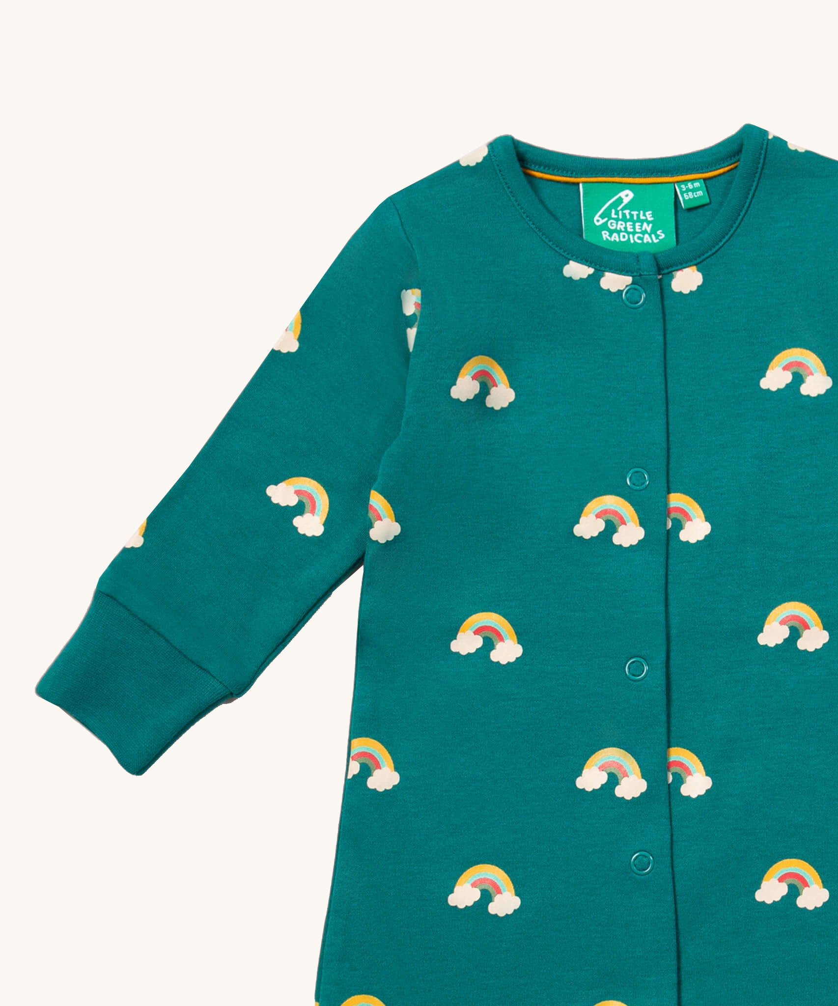 A close up of the Little Green Radicals turquoise rainbow baby grow, showing the popper fastener detail on turquoise organic cotton fabric.