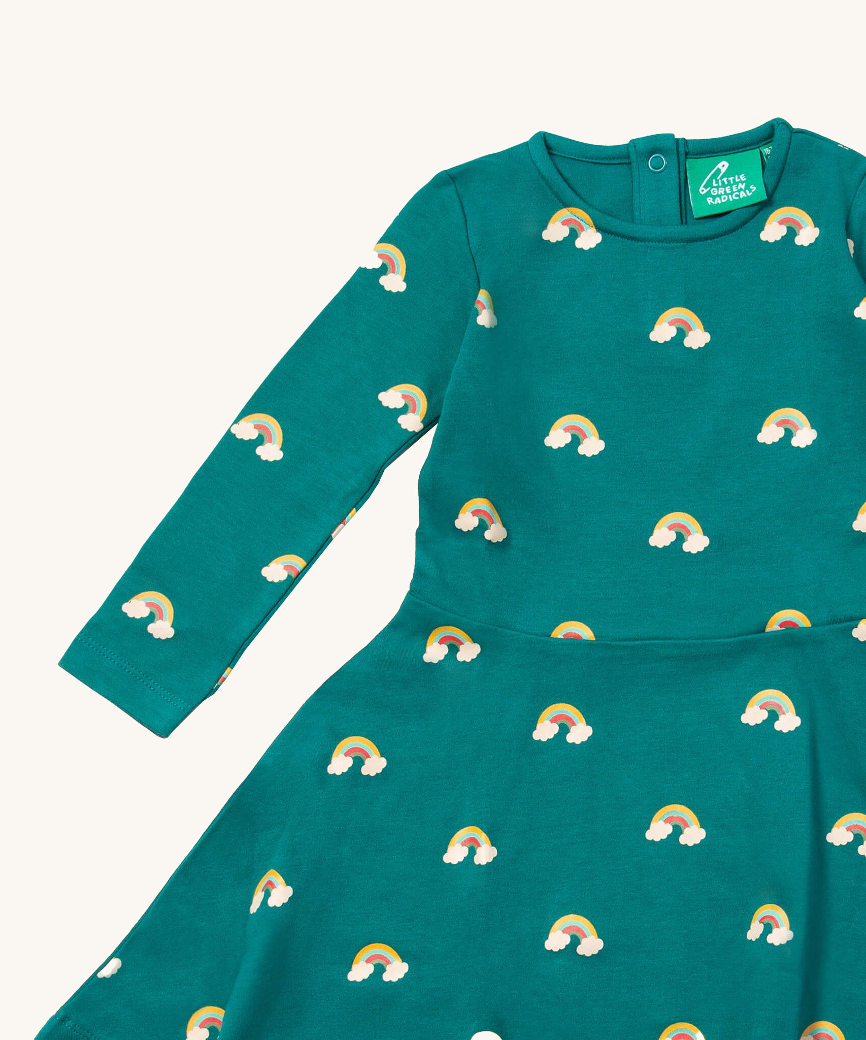 A close up of the Little Green Radicals rainbow turquoise twirly dress showing the long sleeve and popper detail
