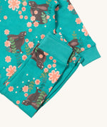 A close up of the Little Green Radicals winter rabbit pyjama set showing the bottoms laid on top of the pyjama top