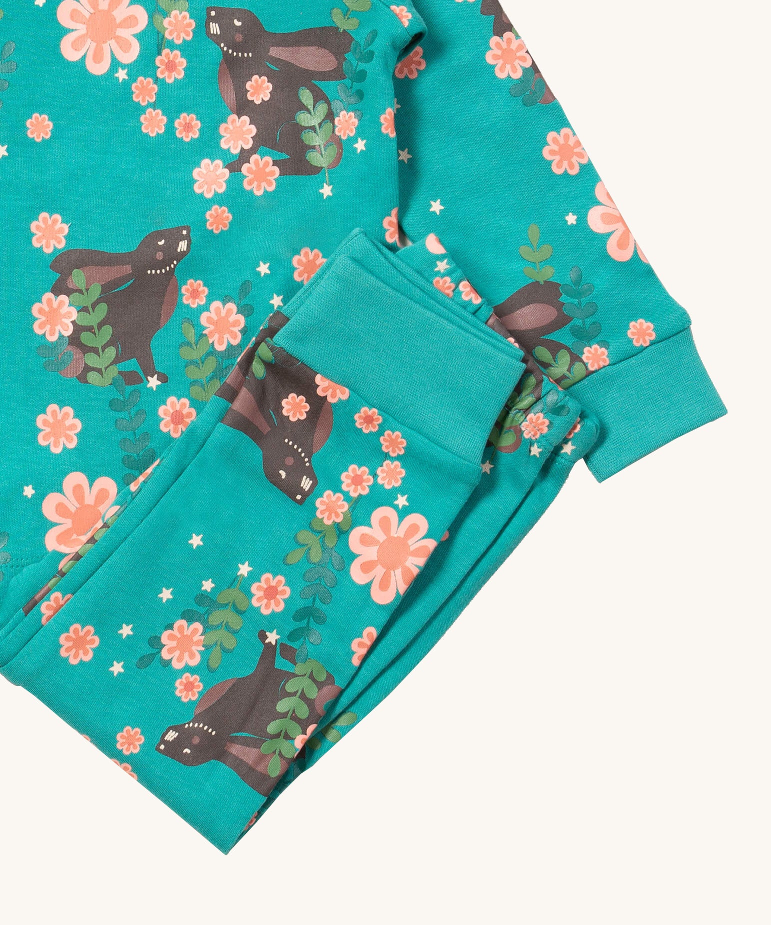 A close up of the Little Green Radicals winter rabbit pyjama set showing the bottoms laid on top of the pyjama top