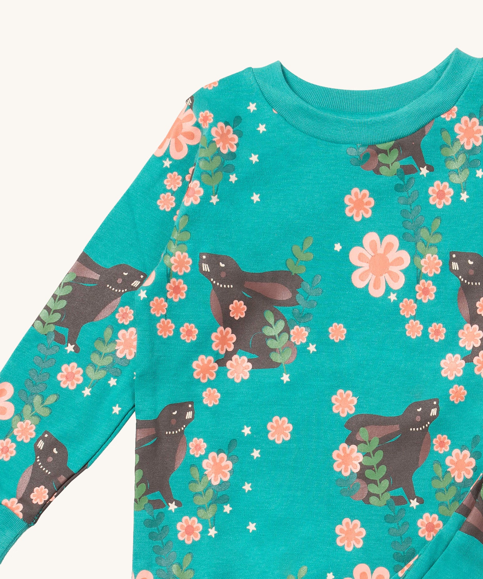 A close up of the Little Green Radicals winter rabbit pyjama top showing the turquoise collar detail with a close up of the brown rabbit print in pink flowers on organic cotton fabric.