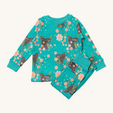 Little Green Radicals winter rabbits pyjama set available at Babipur.. A GOTS organic cotton pyjama top and bottom set in turquoise with matching trim and prints of rabbits in pink flowers