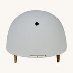 Maël Diffuser, a light grey dome plug-in essential oil diffuser with wooden feet. 