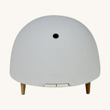 Maël Diffuser, a light grey dome plug-in essential oil diffuser with wooden feet. 