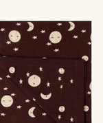Close up of the Little Green Radicals brown moon knitted organic cotton baby blanket.