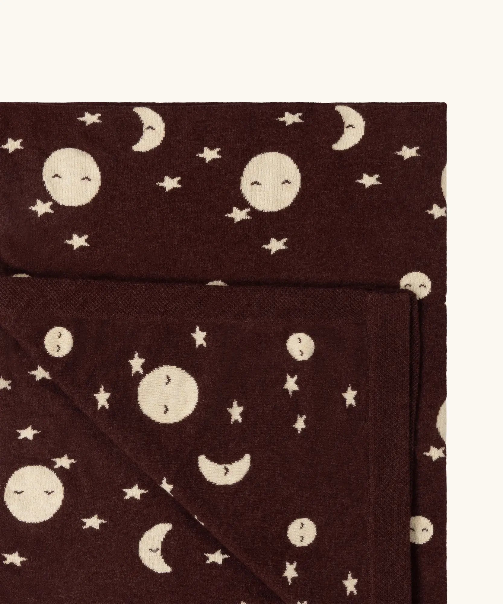 Close up of the Little Green Radicals brown moon knitted organic cotton baby blanket.