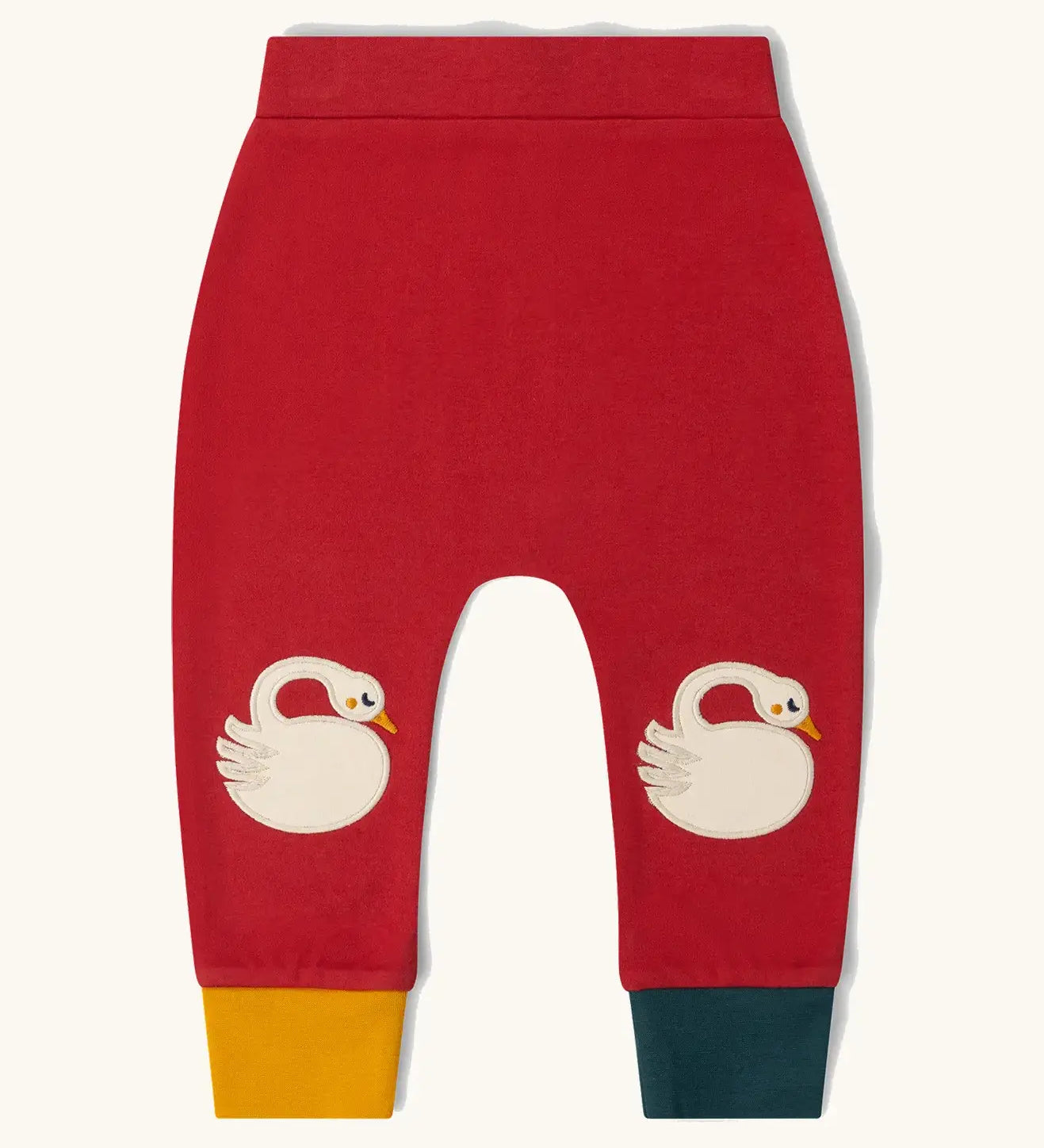 Little Green Radicals organic cotton swans knee patch joggers in red with one yellow and one dark green leg cuff.