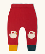 Little Green Radicals organic cotton swans knee patch joggers in red with one yellow and one dark green leg cuff.