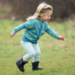 Child running around outside wearing the Little Green Radicals Adaptive Extra Long Blue Striped Joggers pictured on a plain background