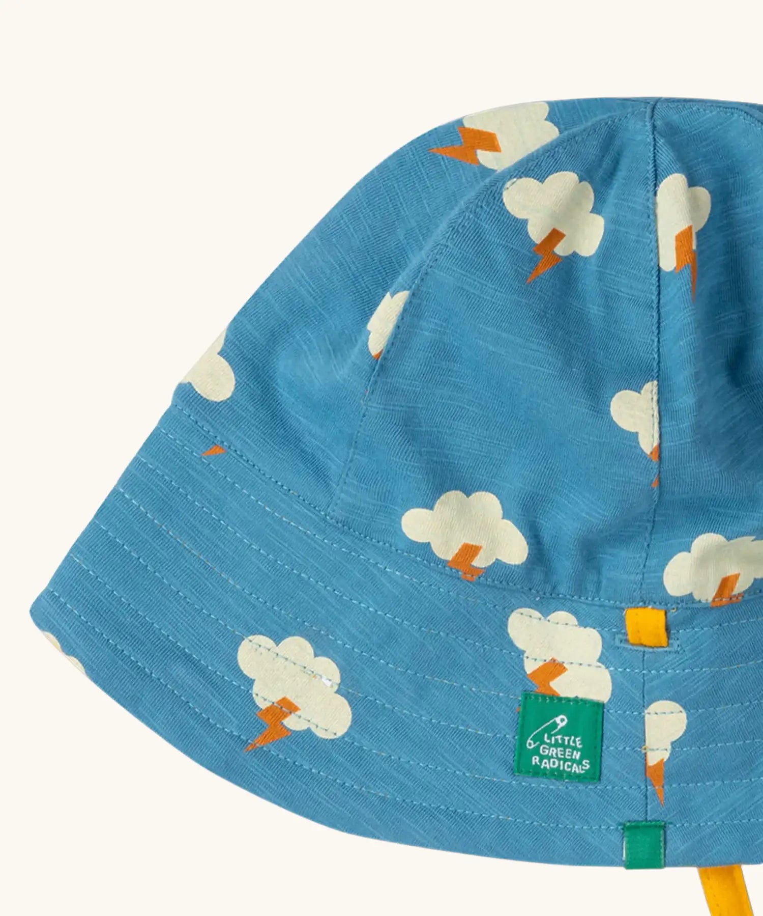 Close up of the Little Green Radicals all weather reversible children's organic cotton sunhat. Blue hat with all over cloud with lightning strike print. 