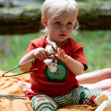Child wearing the Little Green Radicals green apple applique organic short sleeve red t-shirt with cherry knee patch joggers.