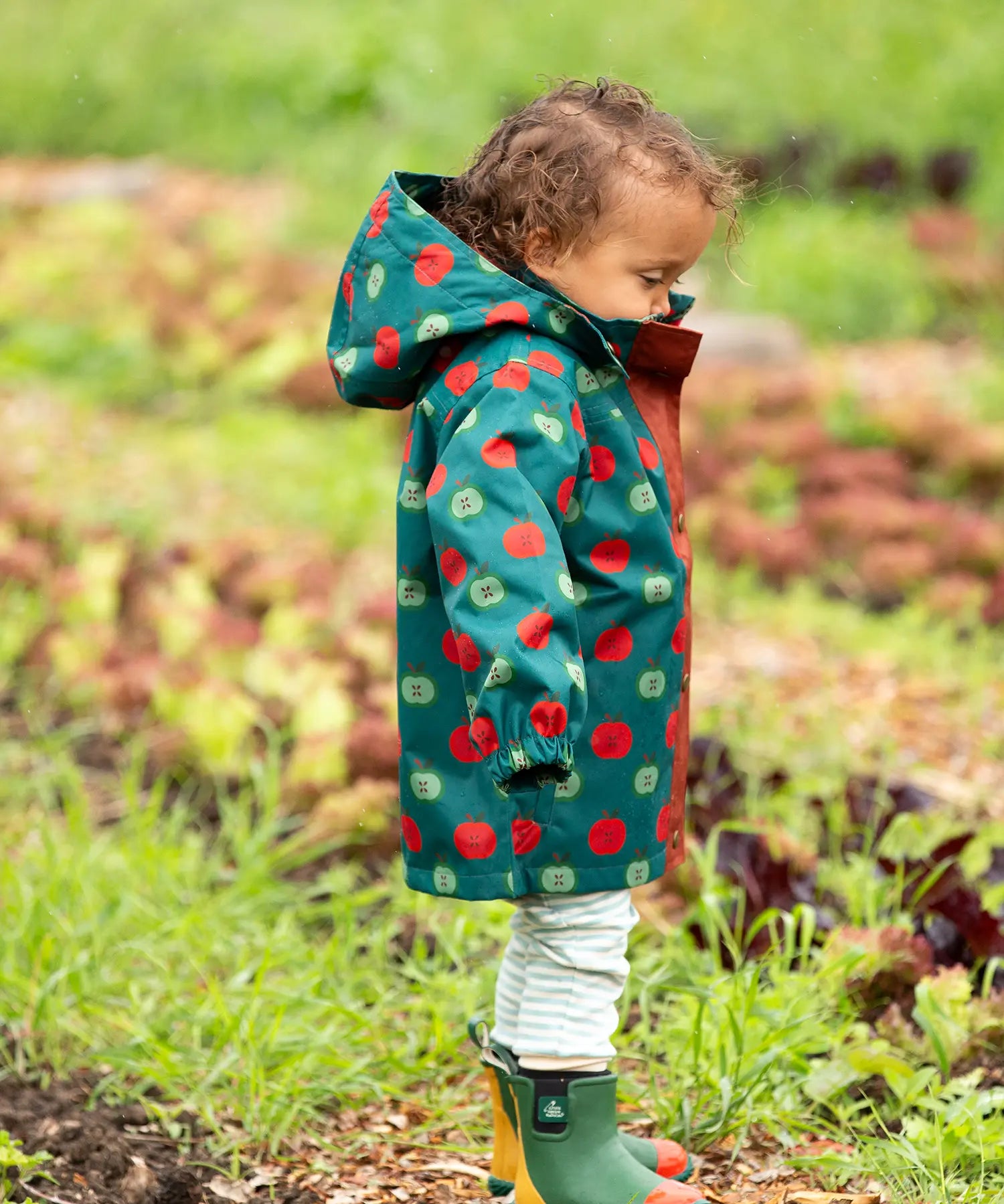 Side of a child wearing Little Green Radicals apple picking recycled waterproof children's raincoat.  