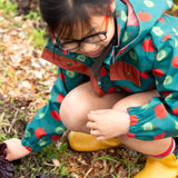 Close up of the zip on the front of the Little Green Radicals apple picking recycled waterproof children's raincoat with a child wearing it.