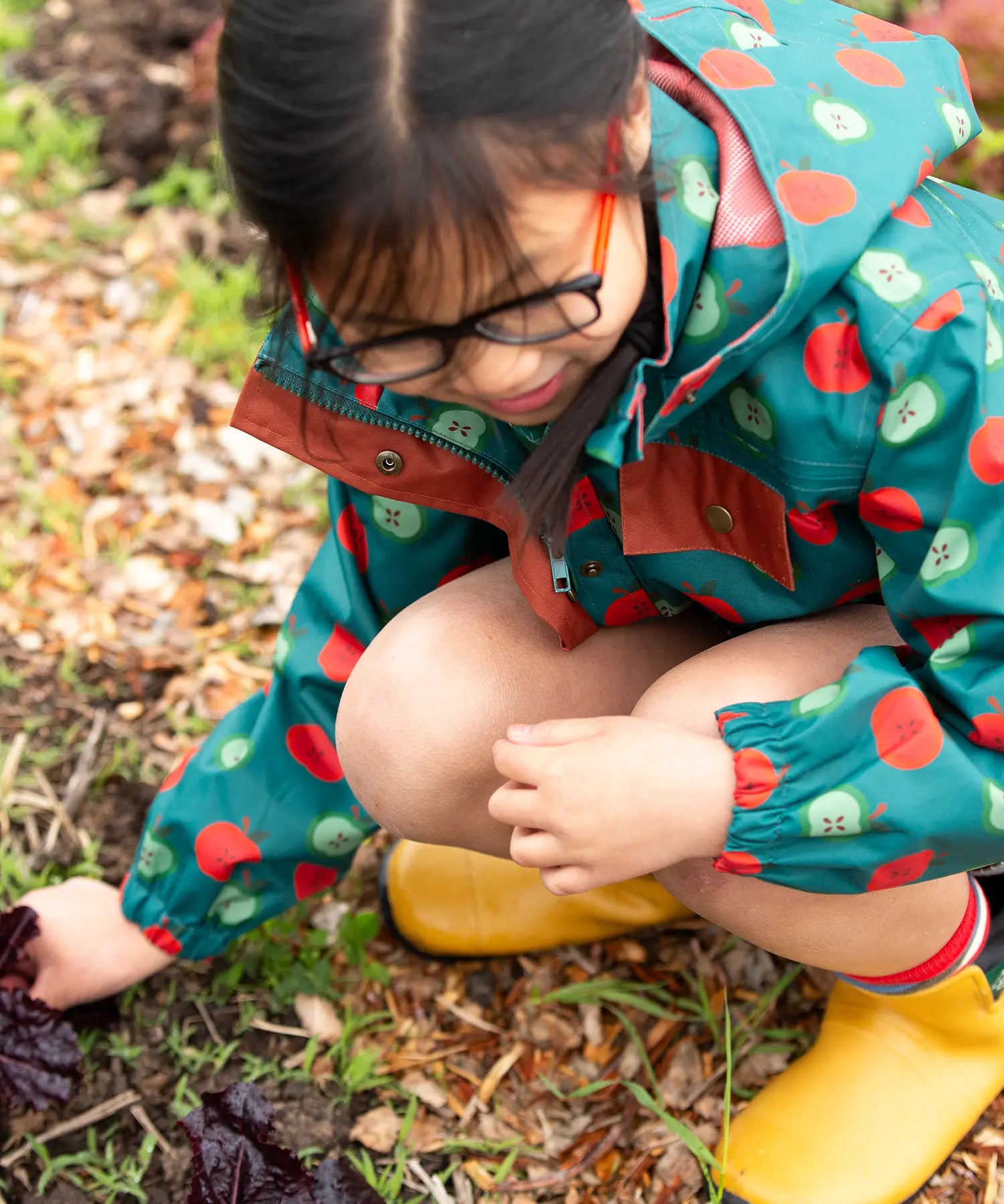 Close up of the zip on the front of the Little Green Radicals apple picking recycled waterproof children's raincoat with a child wearing it.