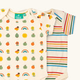 Close up of the Little Green Radicals vintage style cream rainbows organic cotton short sleeved baby bodysuit 2 Pack. One vest with a repeat nature themed print and one with a cream rainbow striped design. 