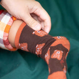 A close up of the Little Green Radicals brown teddy bear organic cotton socks on a child's feet. These socks are part of a wide range of organic cotton clothing and accessories for children available here at Babipur. 
