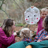 Woman wearing the Little Green Radicals berry check adult classic pyjamas sitting outdoors next to children in Little Green Radicals organic cotton pyjamas.