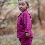 Child wearing the Little Green Radicals berry pink check classic pyjamas.