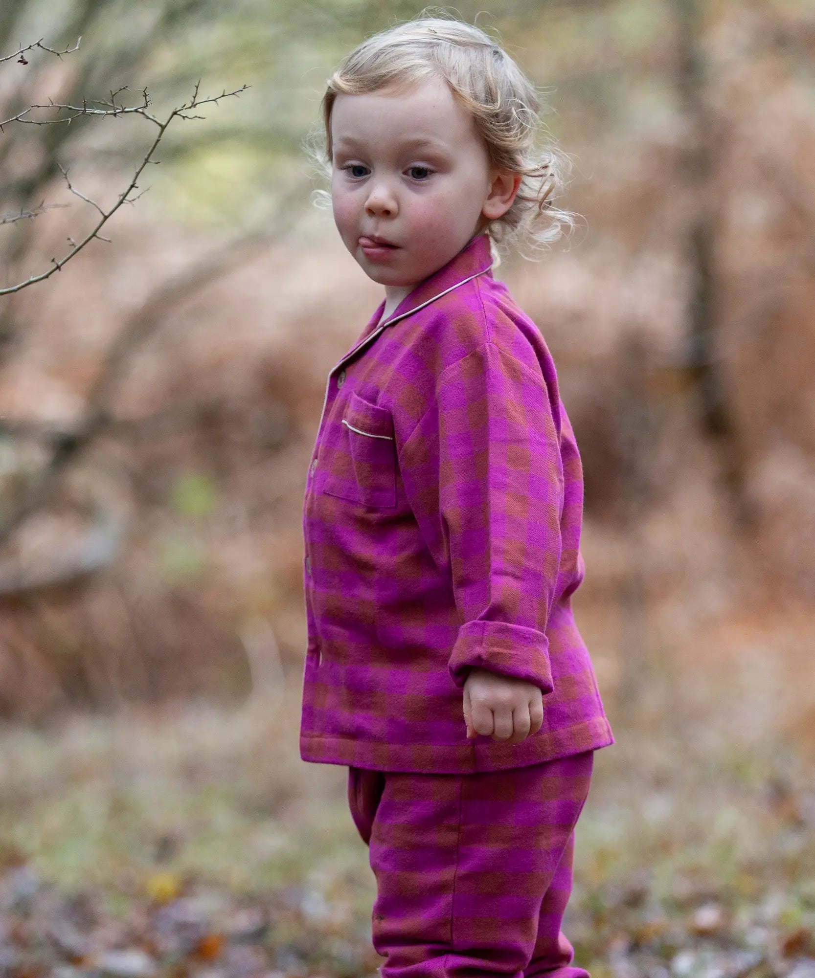 Child wearing the Little Green Radicals berry pink check classic pyjamas.