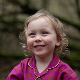Child wearing the Little Green Radicals berry pink check classic pyjamas.