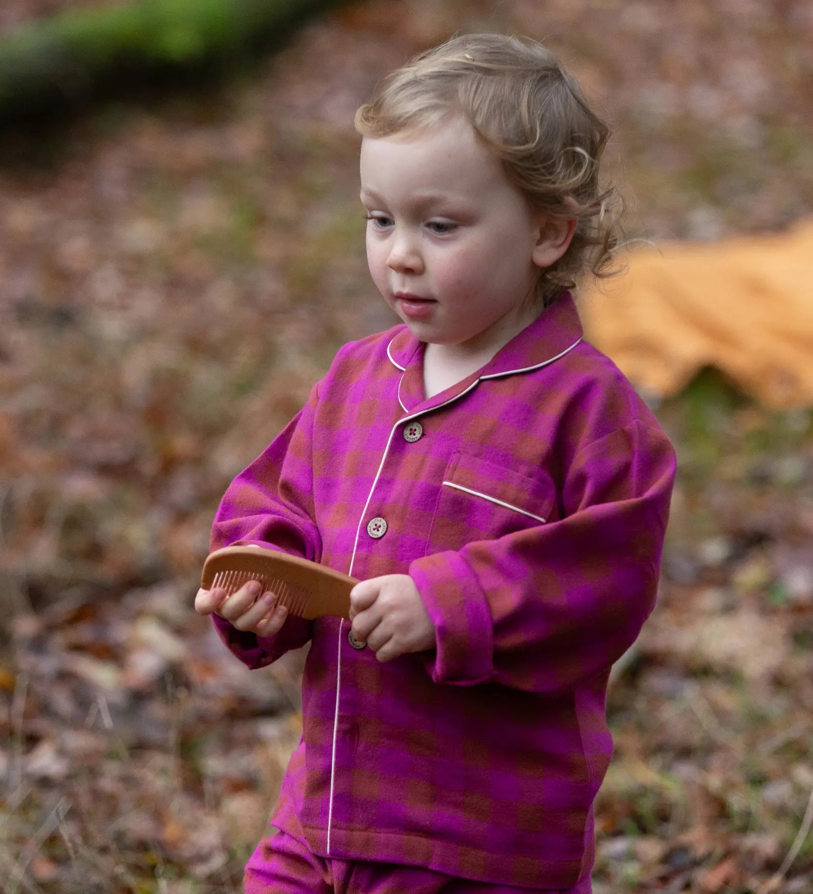 Child wearing the Little Green Radicals berry pink check classic pyjamas.