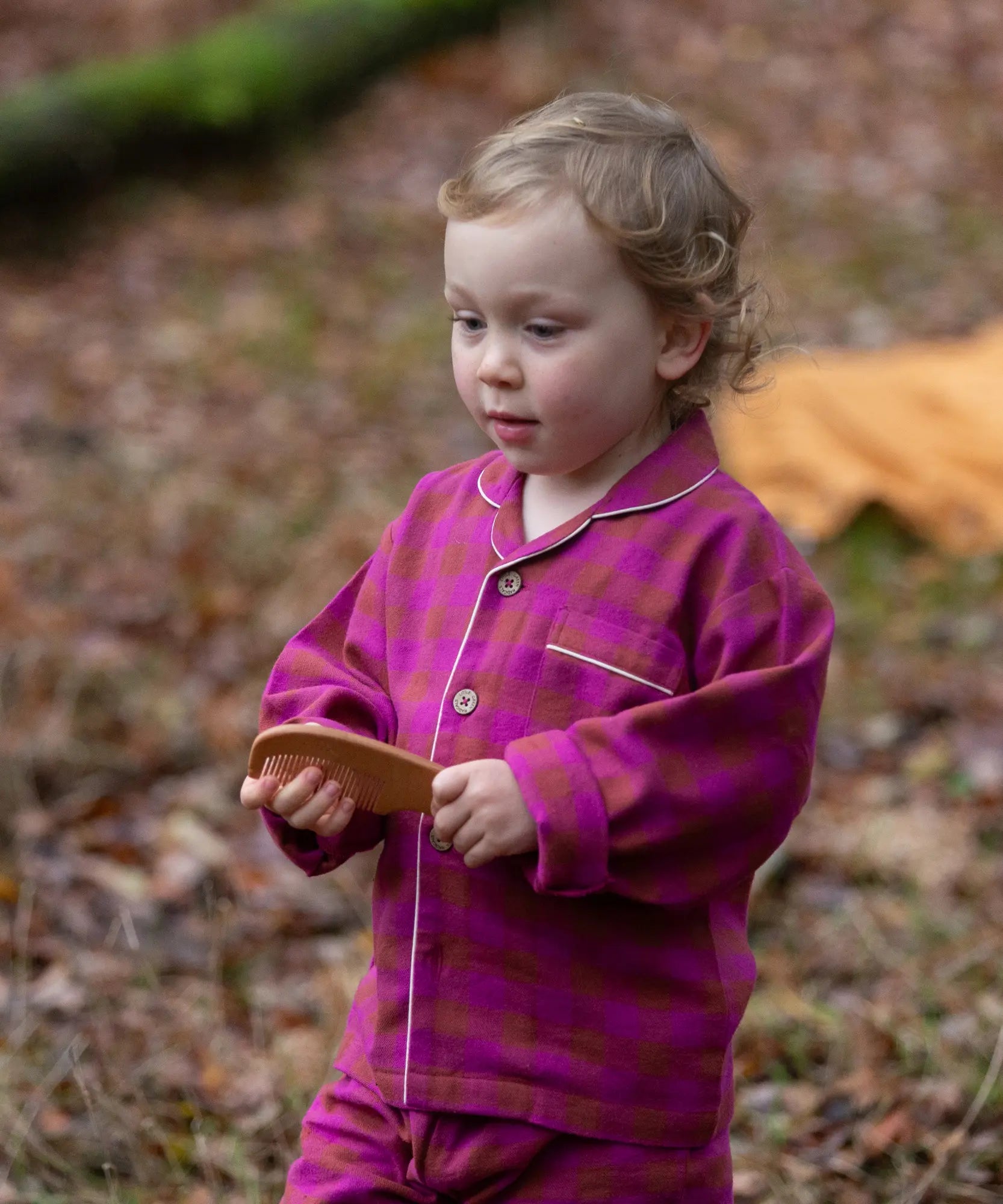 Child wearing the Little Green Radicals berry pink check classic pyjamas.