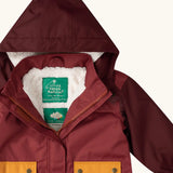 Close up of the Little Green Radicals berry purple recycled waterproof winter coat with the front zip half open showing the fleece lining. 
