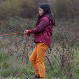 Child wearing a Little Green Radicals  berry purple recycled waterproof winter coat with yellow gold trousers.