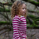 Child wearing the Little Green Radicals berry purple striped long sleeve top. 