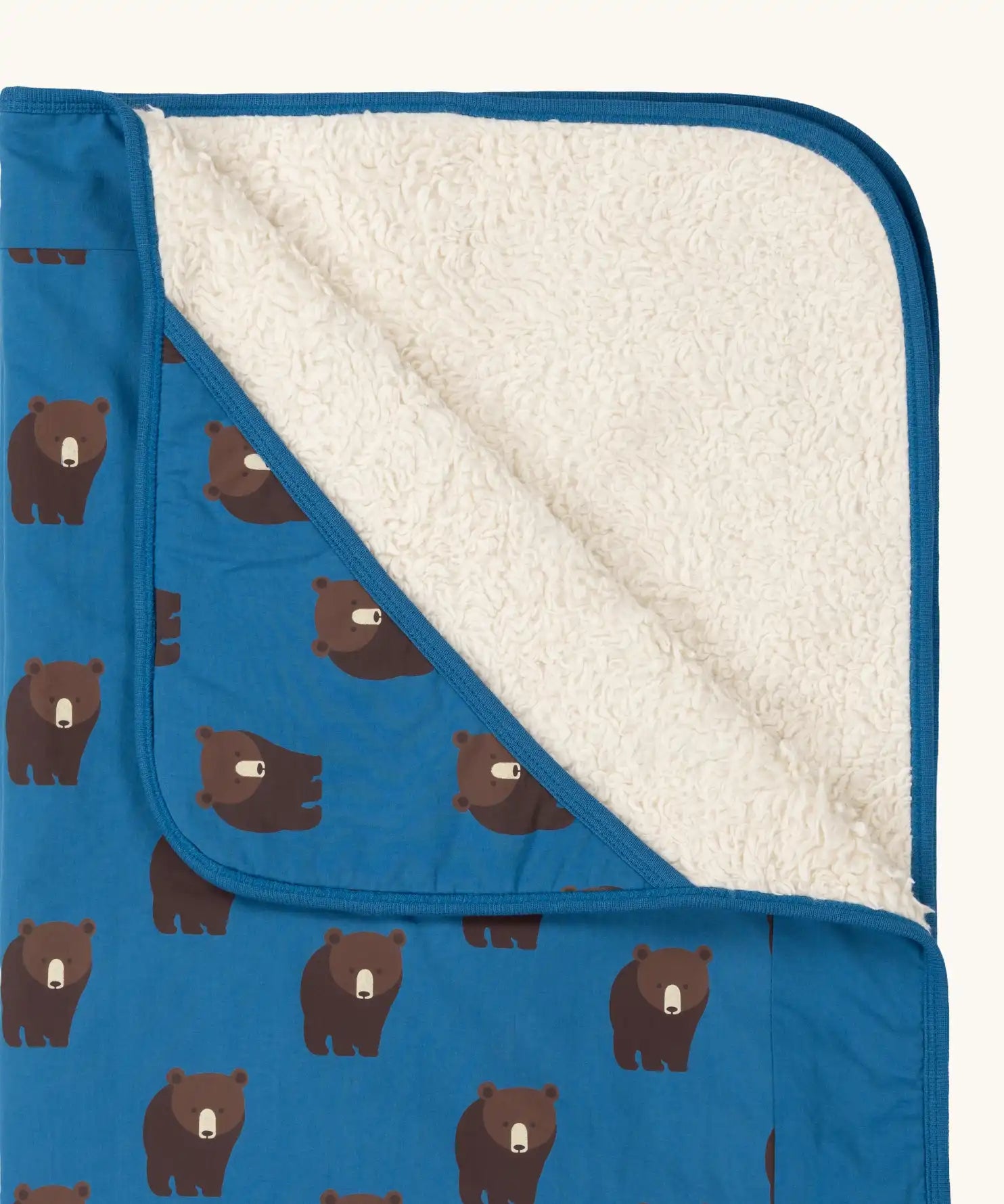 Close up of the Little Green Radicals bears organic sherpa hooded baby blanket showing the fluffy fleece lining. Blue hooded blanket with brown bears print.