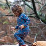 Child wearing Little Green Radicals  blue bears organic cotton pyjamas and striped socks. 