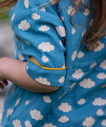 A close up of the short sleeve on the top from the Little Green Radicals Blue Clouds Button Through Pyjama Short Set. The set contains a traditional style, short sleeved shirt style top with matching shorts. The print has a blue background with an over white cloud print. Little green Radicals have a wide range of organic cotton, Fairtrade children's clothing and outerwear available here at Babipur.