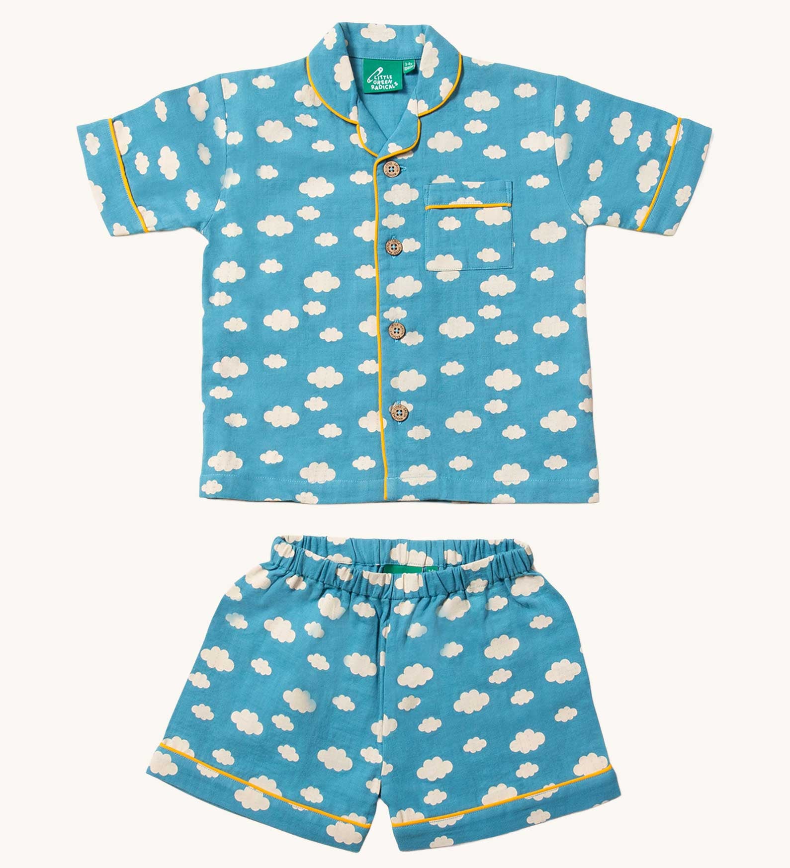 Little Green Radicals Blue Clouds Button Through Pyjama Short Set. The set contains a traditional style, short sleeved shirt style top with matching shorts. The print has a blue background with an over white cloud print. Little green Radicals have a wide range of organic cotton, Fairtrade children's clothing and outerwear available here at Babipur.