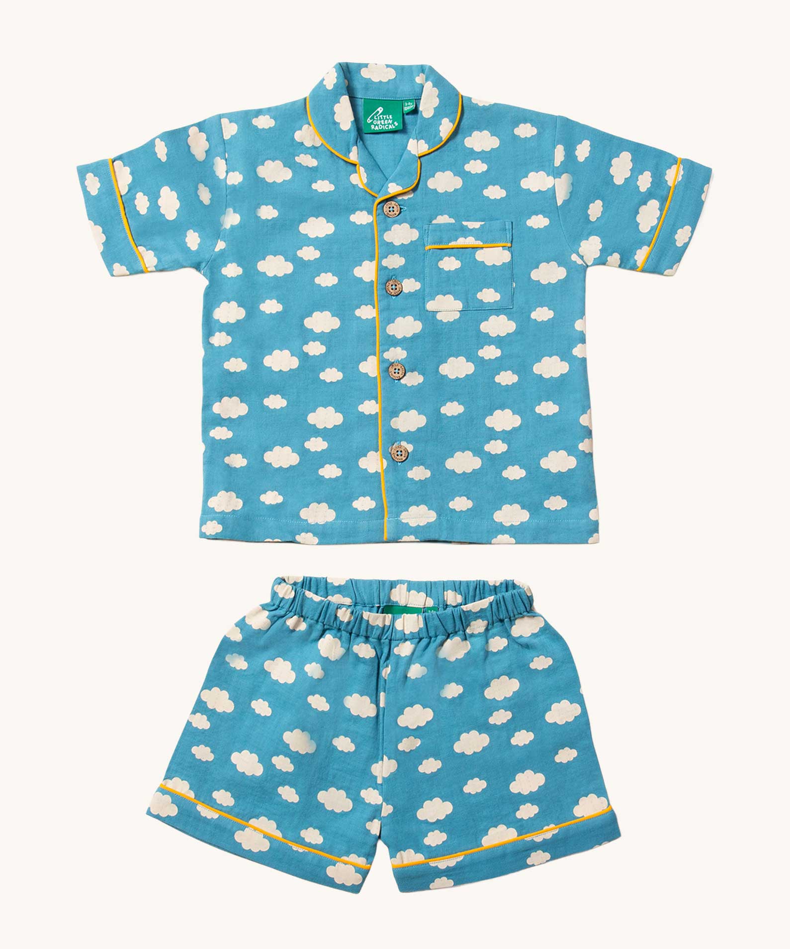 Little Green Radicals Blue Clouds Button Through Pyjama Short Set. The set contains a traditional style, short sleeved shirt style top with matching shorts. The print has a blue background with an over white cloud print. Little green Radicals have a wide range of organic cotton, Fairtrade children's clothing and outerwear available here at Babipur.