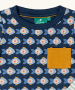 Close up of the Little Green Radicals little fish organic cotton t-shirt from the playset. A navy top with repeat fish print and a yellow chest pocket.