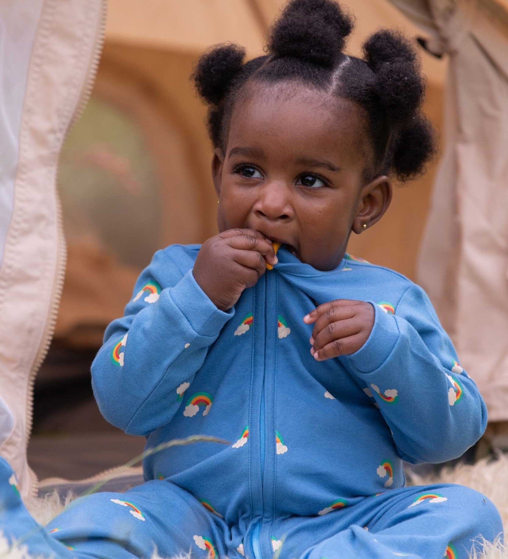 A child wearing the Little Green Radicals Blue Rainbows Zip Organic Babygrow. Little green Radicals have a wide range of organic cotton, Fairtrade clothing and outerwear for babies and children available here at Babipur.