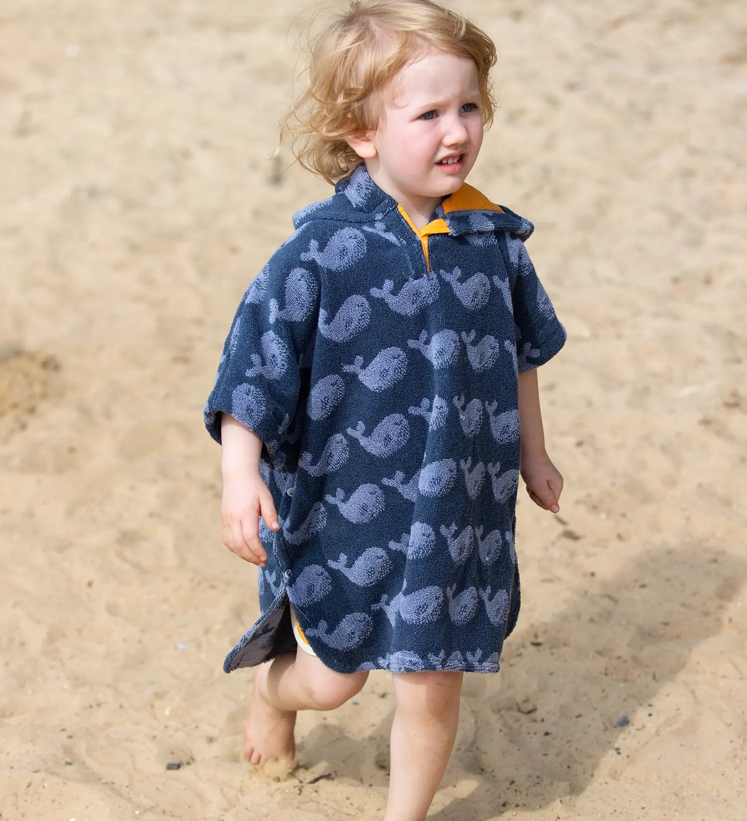 Child wearing the Little Green Radicals clue singing whale kids organic cotton towel poncho. 
