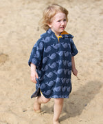 Child wearing the Little Green Radicals clue singing whale kids organic cotton towel poncho. 