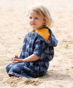 Child wearing the Little Green Radicals clue singing whale kids organic cotton towel poncho. 